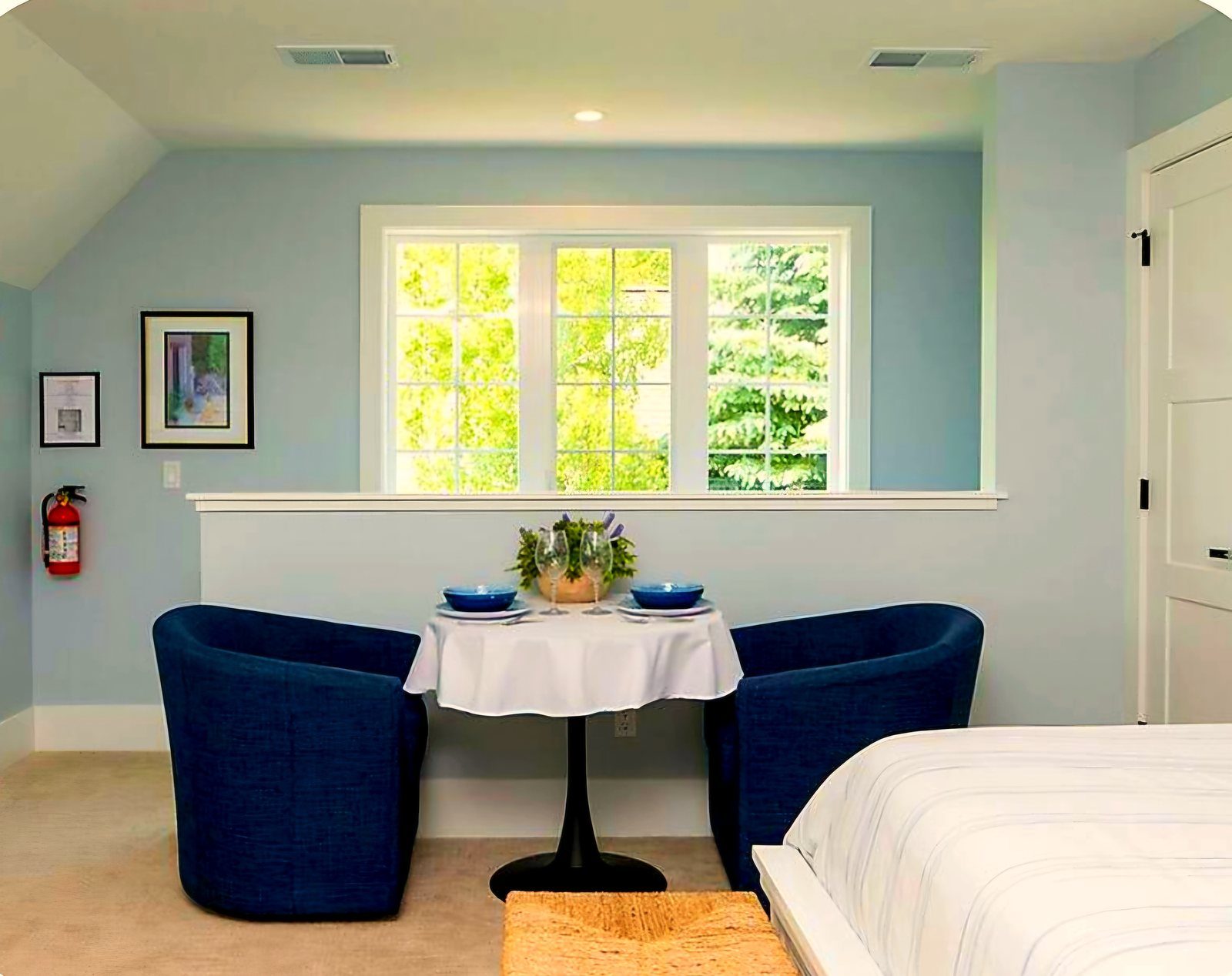 Breakfast nook with blue armchairs and window overlooking trees